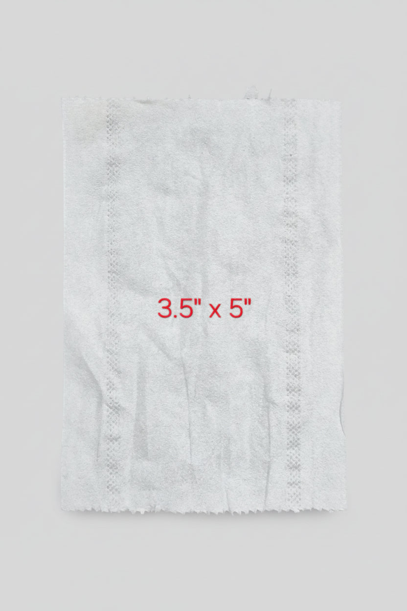 White paper towel with dimensions 3.5" x 5" on a brown surface with a ruler.