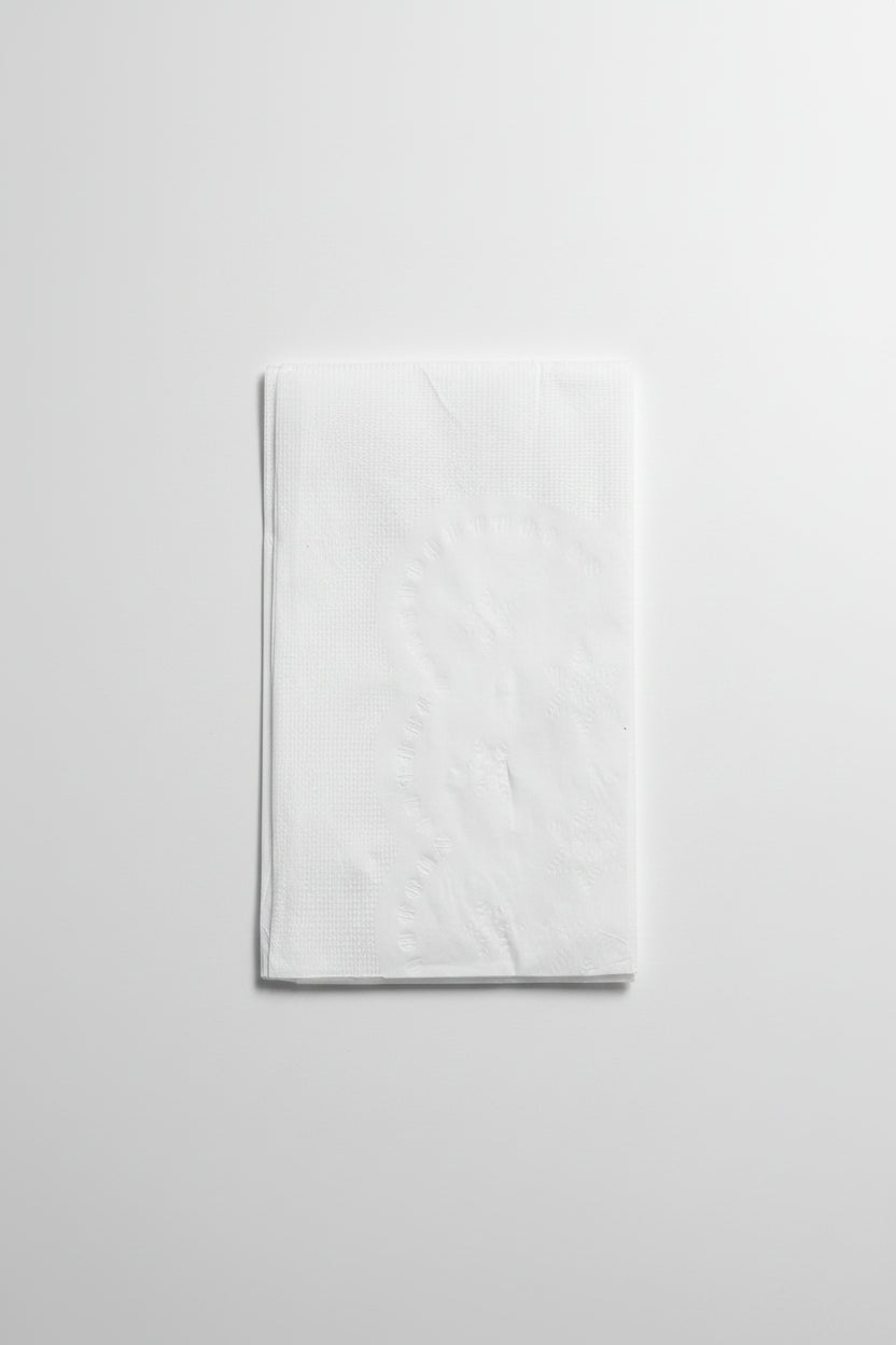 White folded paper with dimensions 4" x 7" on a brown surface with a ruler.