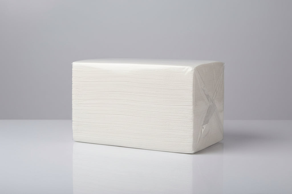 Stack of white paper towels on a gray surface with a blurred background